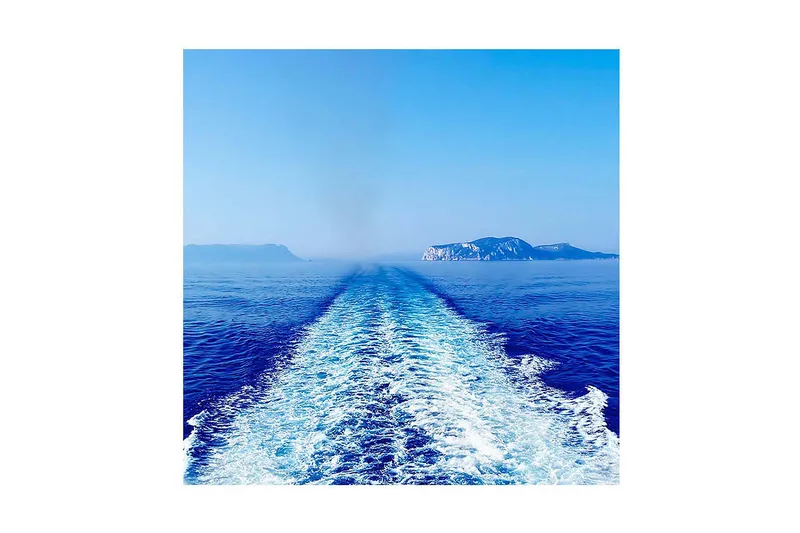 Canvas-taulu 45x45 cm - Kirkas sininen merinäköala ja venereitti kohti kaukaisia kallioita, Sininen / Valkoinen