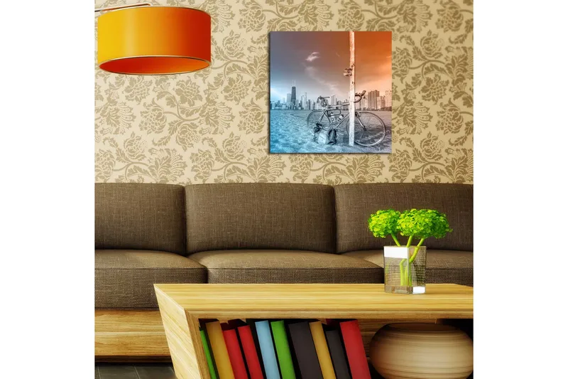Canvas-taulu 45x45 cm - Polkupyörä nojaa tolppaan, taustalla kaupungin siluetti - Sininen / oranssi - Sisustustuotteet - Taulu & taide - Canvas-taulu