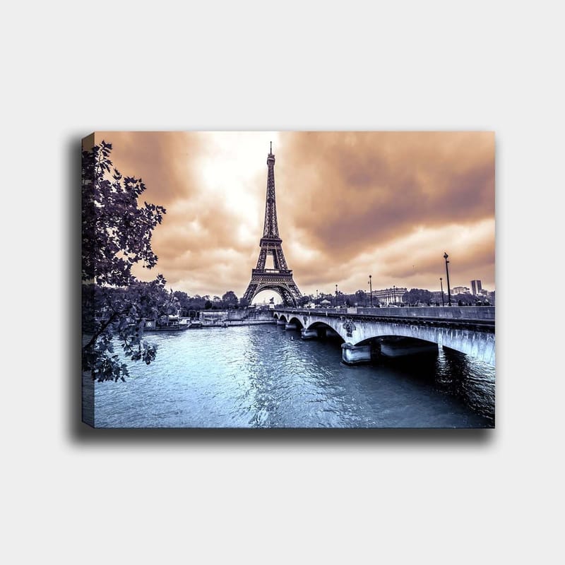 Canvas taulu 70x100 cm - Eiffel-torni kohoaa majesteettisesti Seine-joen ylle dramaattisen taivaan alla, Sininen / Harmaa / Kupari