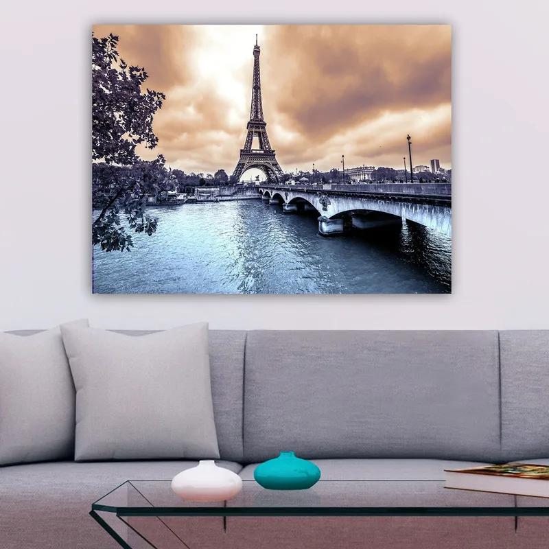 Canvas taulu 70x100 cm - Eiffel-torni kohoaa majesteettisesti Seine-joen ylle dramaattisen taivaan alla - Sininen / Harmaa / Kupari - Sisustustuotteet - Taulu & taide - Canvas-taulu