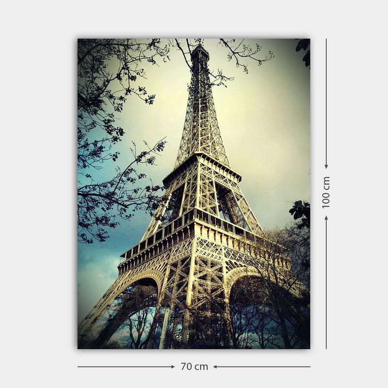 Canvas taulu 70x100 cm - Eiffel-torni Pariisissa, matalasta kulmasta kuvattuna, ympäröiden puiden oksia - Harmaa / Beige / Sininen - Sisustustuotteet - Taulu & taide - Canvas-taulu