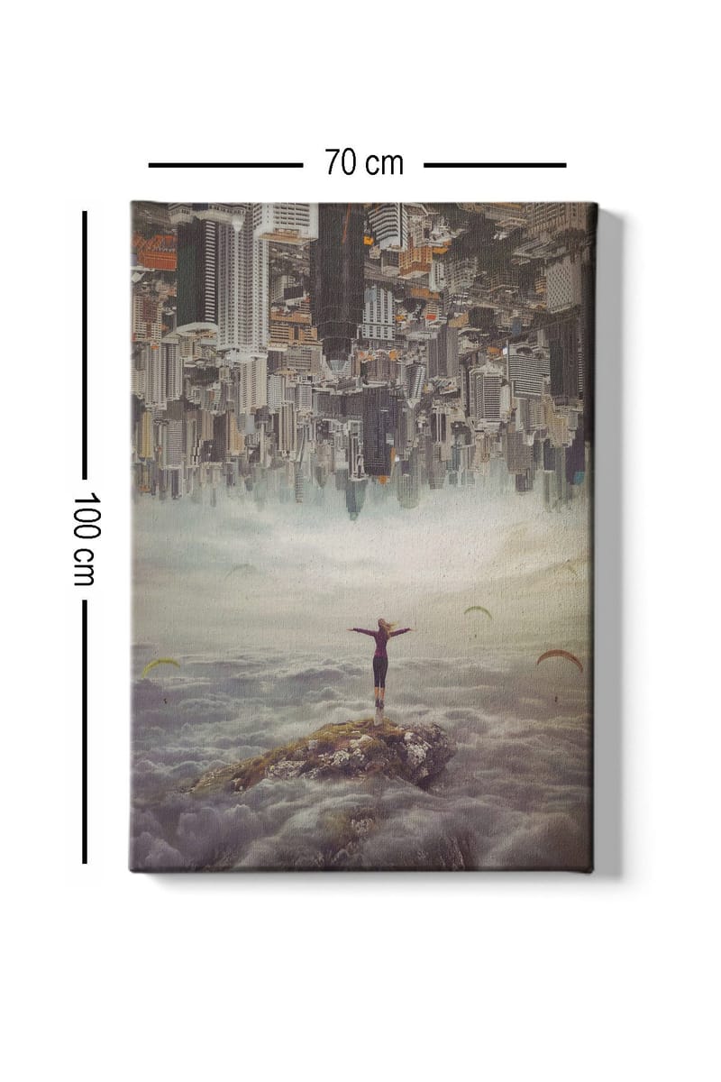 Canvas taulu 70x100 cm - Henkilö seisoo kädet ojennettuina kalliolla pilvien yläpuolella, taustalla ylösalaisin oleva kaupunki - Harmaa / Beige / Tummansininen - Sisustustuotteet - Taulu & taide - Canvas-taulu