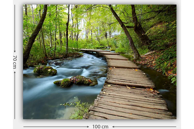 Canvas taulu 70x100 cm - Hiljainen metsäpolku mutkittelee solinaavan puron yli rehevien puiden ja kasvillisuuden ympäröimänä - Vihreä / Ruskea / Sininen - Sisustustuotteet - Taulu & taide - Canvas-taulu