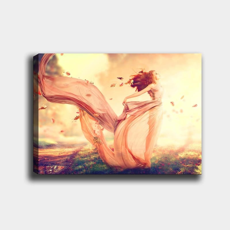 Canvas taulu 70x100 cm - Hulmuavassa mekossa oleva nainen tanssii unenomaisessa syysmaisemassa putoavien lehtien keskellä, Vaaleanpunainen / Beige / Pehmeän keltainen