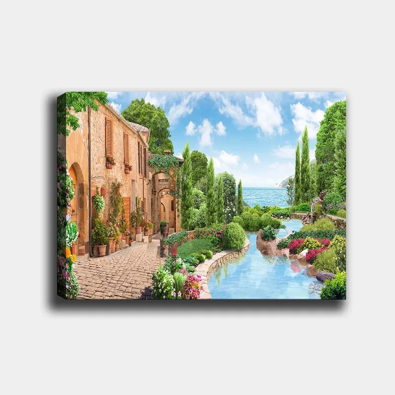 Canvas taulu 70x100 cm - Idyllinen maaseutukylä kukkien, puiden ja kimaltelevan järven taustalla, Vihreä / Sininen / Terrakotta