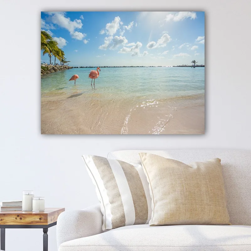 Canvas taulu 70x100 cm - Kaksi flamingoja seisoo rannalla kirkkaassa, turkoosissa meressä, Vaaleanpunainen / Turkoosi / Beige