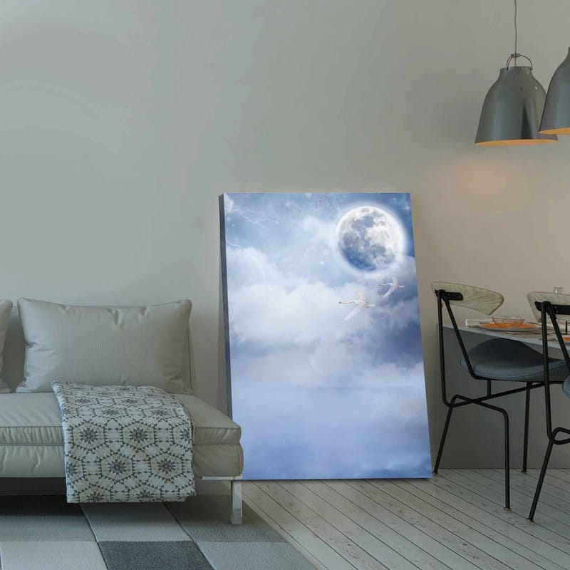 Canvas taulu 70x100 cm - Kaksi joutsenta lentää suuren kuun alla unenomaisella, pilvisellä taivaalla - Vaaleansininen / Valkoinen / Tummansininen - Sisustustuotteet - Taulu & taide - Canvas-taulu