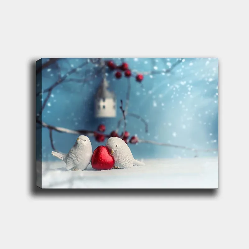 Canvas taulu 70x100 cm - Kaksi lintua pitelevät punaista sydäntä yhdessä talvisessa ympäristössä, Valkoinen / Punainen / Sininen