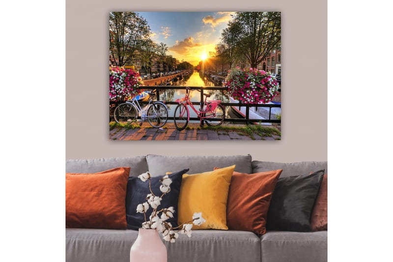 Canvas taulu 70x100 cm - Kaksi polkupyörää viehättävässä kanavamaisemassa kukkien ja auringonlaskun keskellä - Vaaleanpunainen / Valkoinen / Vihreä - Sisustustuotteet - Taulu & taide - Canvas-taulu