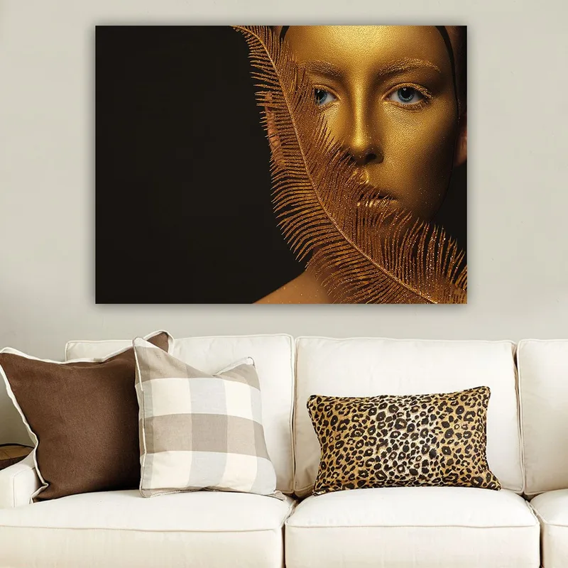 Canvas taulu 70x100 cm - Kasvokuva kultaisella pinnalla ja sinisillä silmillä, koristeellisen höyhenmäisen rakenteen ympäröimänä, Kulta / Sininen