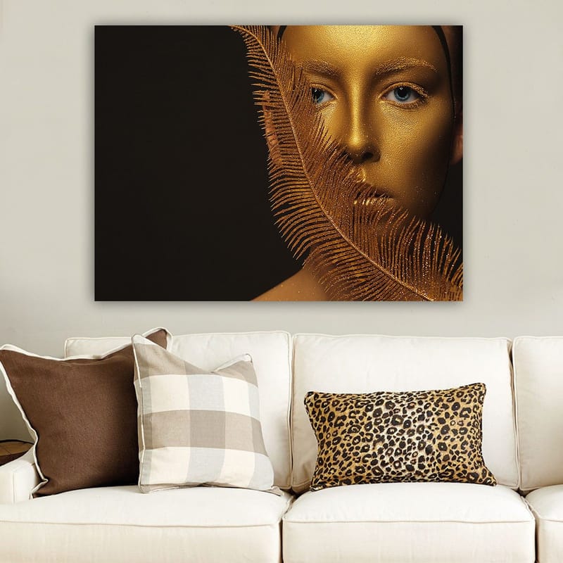 Canvas taulu 70x100 cm - Kasvokuva kultaisella pinnalla ja sinisillä silmillä, koristeellisen höyhenmäisen rakenteen ympäröimänä, Kulta / Sininen