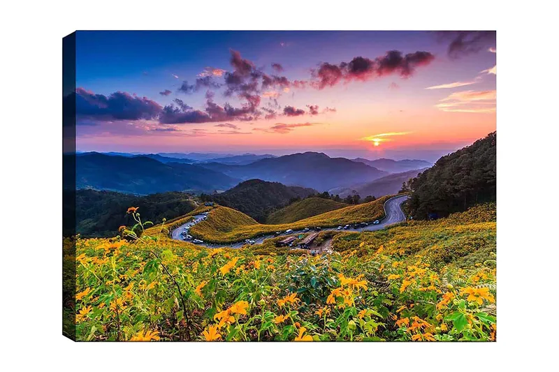 Canvas taulu 70x100 cm - Kaunis auringonlasku kukkivan laakson yllä, taustalla mutkittelevat tiet ja vuoret, Keltainen / Vihreä / Sininen