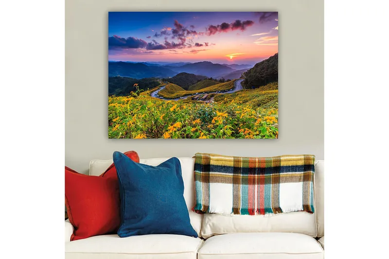 Canvas taulu 70x100 cm - Kaunis auringonlasku kukkivan laakson yllä, taustalla mutkittelevat tiet ja vuoret - Keltainen / Vihreä / Sininen - Sisustustuotteet - Taulu & taide - Canvas-taulu