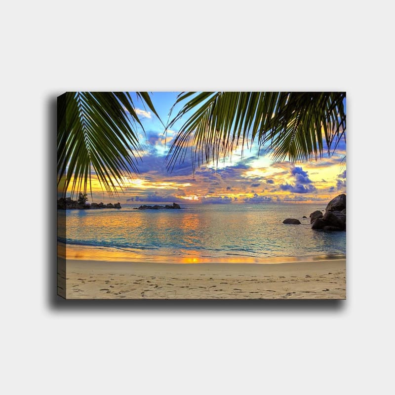 Canvas taulu 70x100 cm - Kaunis auringonlasku rannalla, palmujen reunustamana aiheen yllä, Sininen / Oranssi / Vihreä