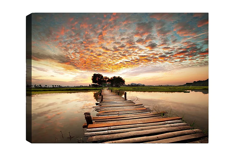 Canvas taulu 70x100 cm - Kaunis auringonlasku peilimäisen järven ylittävän puisen sillan yli, Oranssi / Sininen / Vihreä
