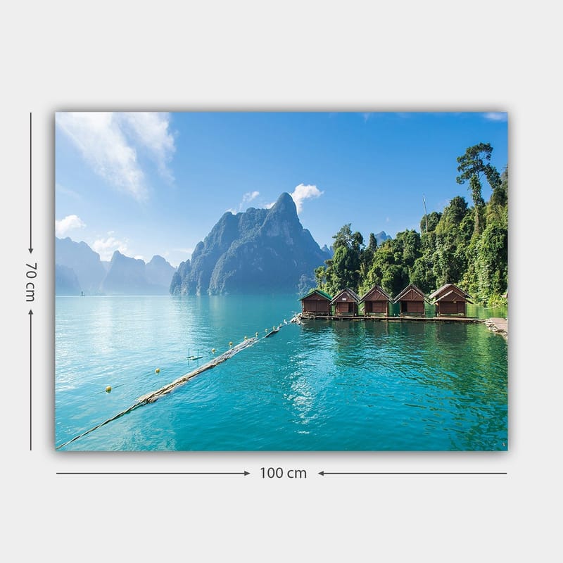 Canvas taulu 70x100 cm - Kaunis järvi mökkineen veden äärellä, majesteettisten vuorten ja rehevän metsän ympäröimänä - Turkoosi / Vihreä / Ruskea - Sisustustuotteet - Taulu & taide - Canvas-taulu