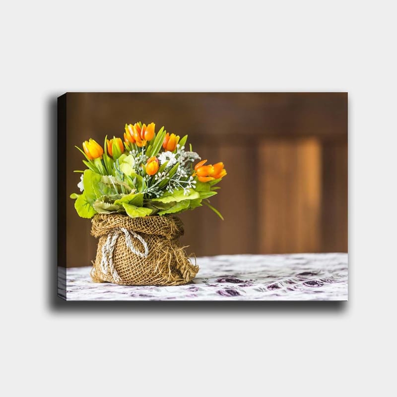 Canvas taulu 70x100 cm - Kaunis kimppu oransseja tulppaaneja ja vihreitä lehtiä juuttikorissa, Oranssi / Vihreä / Valkoinen