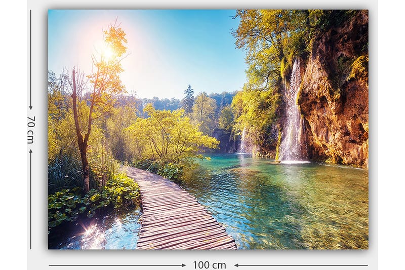 Canvas taulu 70x100 cm - Kaunis luontonäkymä, jossa puinen silta johtaa rehevän vehreyden läpi ja taustalla vesiputous - Vihreä / Sininen / Keltainen - Sisustustuotteet - Taulu & taide - Canvas-taulu