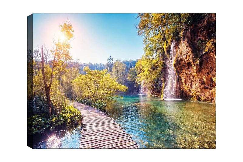 Canvas taulu 70x100 cm - Kaunis luontonäkymä, jossa puinen silta johtaa rehevän vehreyden läpi ja taustalla vesiputous, Vihreä / Sininen / Keltainen