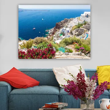 Canvas taulu 70x100 cm - Kaunis näkymä Santorinille valkoisine taloineen ja kukineen koristaen kallioita meren rannalla - Sininen / Valkoinen / Vihreä - Sisustustuotteet - Taulu & taide - Canvas-taulu