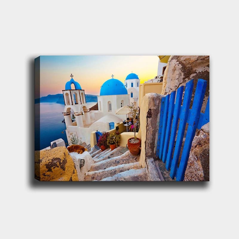 Canvas taulu 70x100 cm - Kaunis näkymä valkoisista rakennuksista sinisine kupoleineen kreikkalaisessa kylässä meren rannalla, Sininen / Valkoinen / Beige