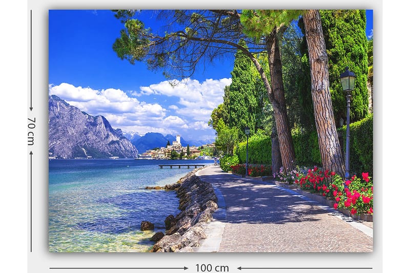 Canvas taulu 70x100 cm - Kaunis rantakatu puiden ja kukkien ympäröimänä järven rannalla, vuorten ympäröimänä ja taustalla viehättävä kaupunki - Sininen / Vihreä / Punainen - Sisustustuotteet - Taulu & taide - Canvas-taulu