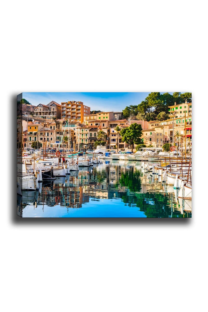 Canvas taulu 70x100 cm - Kaunis satama purjeveneineen ja värikkäine taloineen veden äärellä, Sininen / Vihreä / Oranssi