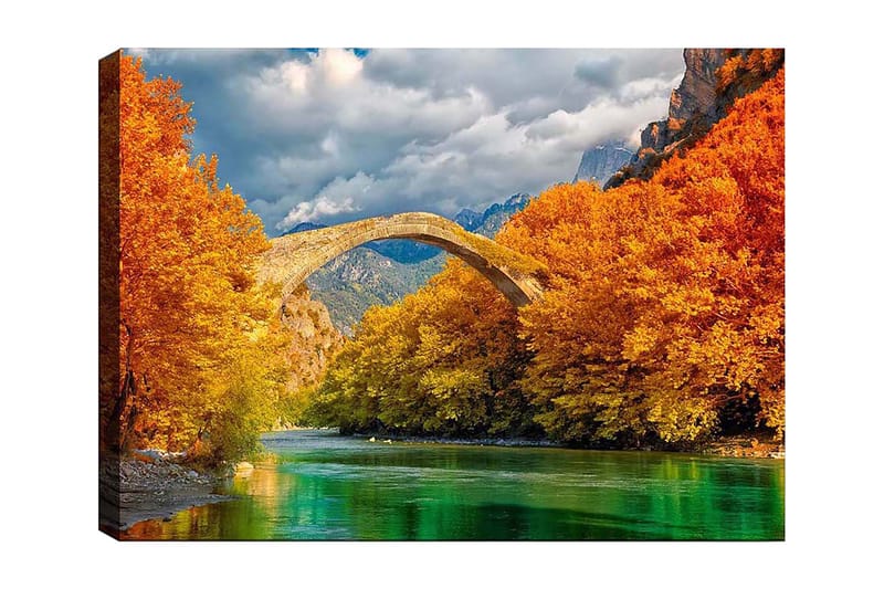 Canvas taulu 70x100 cm - Kaunis syysmaisema vanhalla kivisillalla, joka ylittää kimaltelevan joen värikkäiden puiden ympäröimänä, Oranssi / Vihreä / Sininen