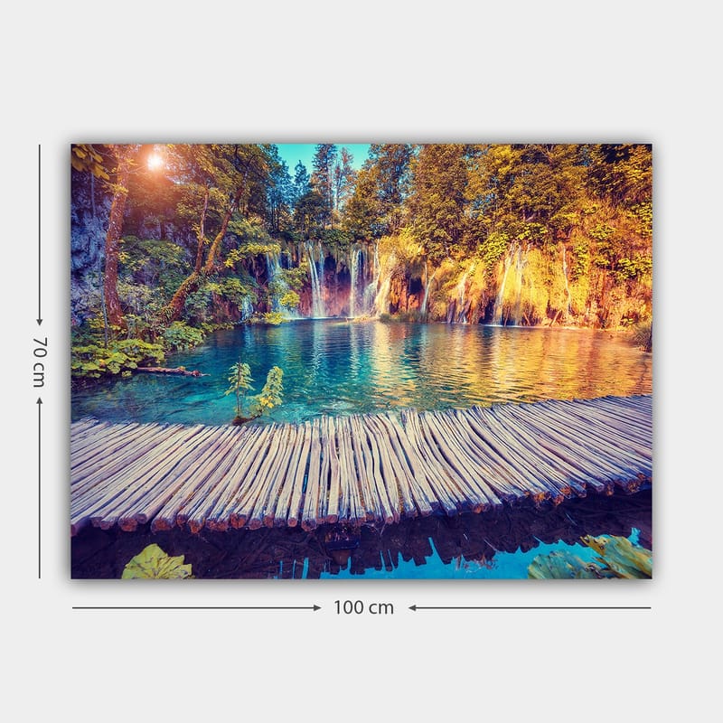 Canvas taulu 70x100 cm - Kaunis vesiputousmaisema kirkkaan sinisellä vedellä, rehevän vehreyden ja puiden ympäröimänä - Sininen / Vihreä / Ruskea - Sisustustuotteet - Taulu & taide - Canvas-taulu