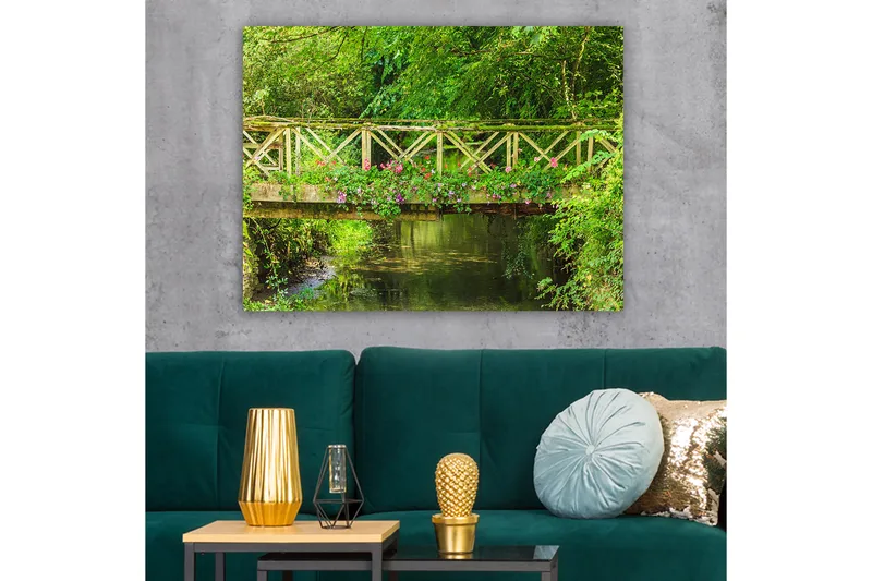 Canvas taulu 70x100 cm - Kaunis puinen silta, jota ympäröi vehreys ja kukat tyynen veden äärellä - Vihreä / Vaaleanpunainen / Ruskea - Sisustustuotteet - Taulu & taide - Canvas-taulu
