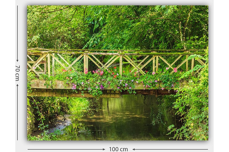 Canvas taulu 70x100 cm - Kaunis puinen silta, jota ympäröi vehreys ja kukat tyynen veden äärellä - Vihreä / Vaaleanpunainen / Ruskea - Sisustustuotteet - Taulu & taide - Canvas-taulu