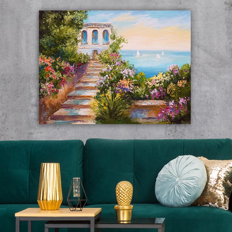 Canvas taulu 70x100 cm - Kaunis portaikko, jota ympäröivät värikkäät kukat, johtavat alas merelle ja rakennukseen, jossa on siniset ikkunat - Vihreä / Vaaleanpunainen / Sininen - Sisustustuotteet - Taulu & taide - Canvas-taulu