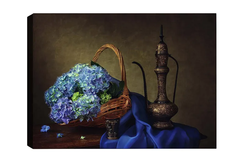 Canvas taulu 70x100 cm - Kaunista tyyneyttä sinisten hortensioiden täyttämän korin ja elegantin metallikannun kera, Sininen / Vihreä / Ruskea