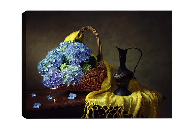 Canvas taulu 70x100 cm - Kaunista tyyneyttä sinisten hortensioiden täyttämän korin ja elegantin mustan kannun kera, Sininen / Keltainen / Vihreä