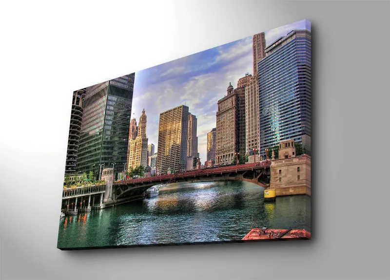 Canvas taulu 70x100 cm - Kaupungin siluetti moderneilla pilvenpiirtäjillä ja silta vesiväylän yli, Sininen / Vihreä / Beige