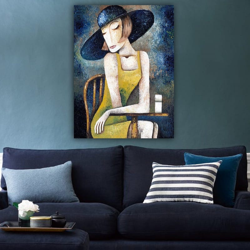 Canvas taulu 70x100 cm - Keltaiseen mekkoon pukeutunut nainen istuu pöydän ääressä valkoisen kupin kanssa, päässään suuri musta hattu - Keltainen / Musta / Sinivihreä - Sisustustuotteet - Taulu & taide - Canvas-taulu