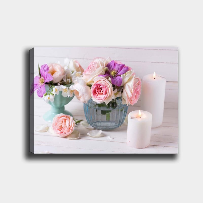 Canvas taulu 70x100 cm - Kimpussa vaaleanpunaisia ja violetteja kukkia lasimaljakossa, valkoisten kynttilöiden ympäröimänä - Vaaleanpunainen / Violetti / Vihreä - Sisustustuotteet - Taulu & taide - Canvas-taulu