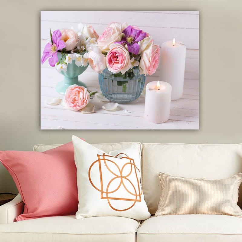 Canvas taulu 70x100 cm - Kimpussa vaaleanpunaisia ja violetteja kukkia lasimaljakossa, valkoisten kynttilöiden ympäröimänä, Vaaleanpunainen / Violetti / Vihreä