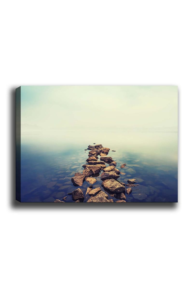 Canvas taulu 70x100 cm - Kivinen polku, joka ulottuu tyynen veden pinnan yli, Harmaa / Sininen / Beige