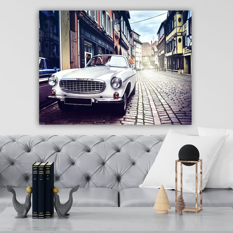 Canvas taulu 70x100 cm - Klassinen valkoinen auto pysäköitynä viehättävälle, vanhanaikaiselle kadulle historiallisten rakennusten ympäröimänä - Valkoinen / Musta / Harmaa - Sisustustuotteet - Taulu & taide - Canvas-taulu