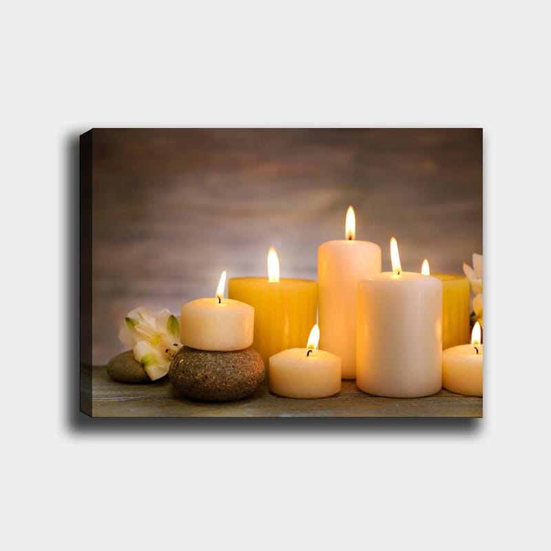 Canvas taulu 70x100 cm - Kokoelma erimuotoisia ja -kokoisia kynttilöitä, joita ympäröivät kivet ja kukka, Keltainen / Valkoinen / Beige