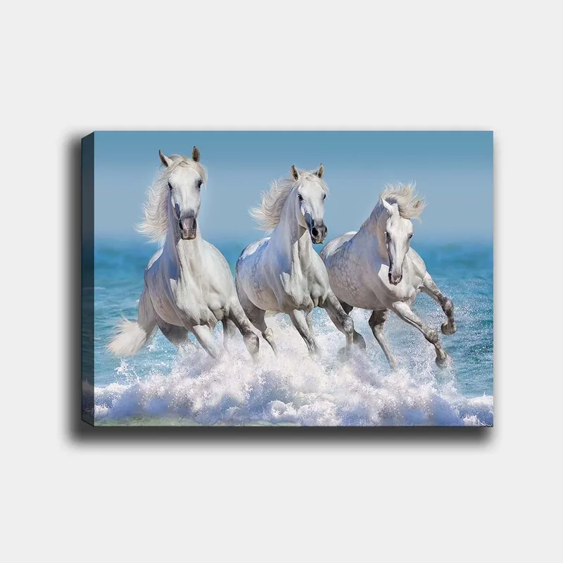 Canvas taulu 70x100 cm - Kolme valkoista hevosta laukkaa aaltojen läpi meren rannalla, Valkoinen / Vaaleansininen / Turkoosi