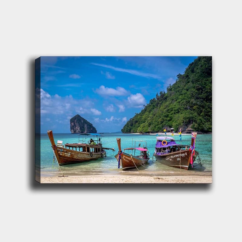 Canvas taulu 70x100 cm - Kolme perinteistä pitkävenettä rannalla, taustalla kivinen saari, Ruskea / Turkoosi / Vihreä