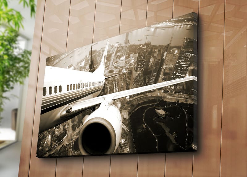 Canvas taulu 70x100 cm - Lentokone leijuu kaupungin yllä hämärässä - Musta / Valkoinen / Harmaa - Sisustustuotteet - Taulu & taide - Canvas-taulu