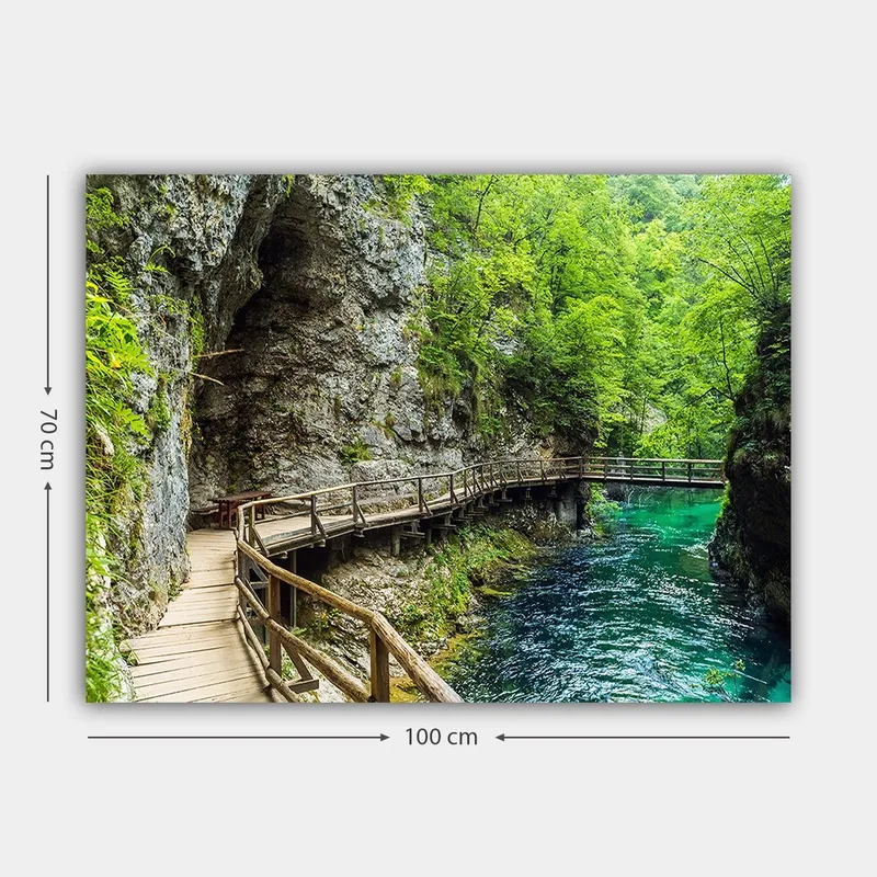 Canvas taulu 70x100 cm - Maisemanäkymä puisesta sillasta, joka mutkittelee rehevän rotkon läpi kirkkaan, turkoosin joen varrella - Vihreä / Turkoosi / Harmaa - Sisustustuotteet - Taulu & taide - Canvas-taulu