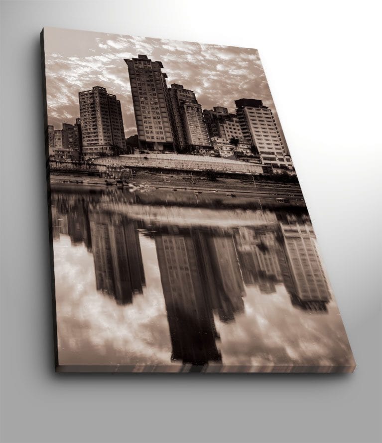 Canvas taulu 70x100 cm - Mustavalkoinen kaupunkisiluetti, jossa korkeat rakennukset heijastuvat veteen, Musta / Valkoinen / Harmaa