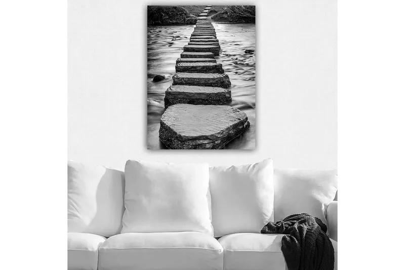 Canvas taulu 70x100 cm - Mustavalkoinen kuva kivistä, jotka muodostavat polun veden pinnalla, Musta / Valkoinen / Harmaa