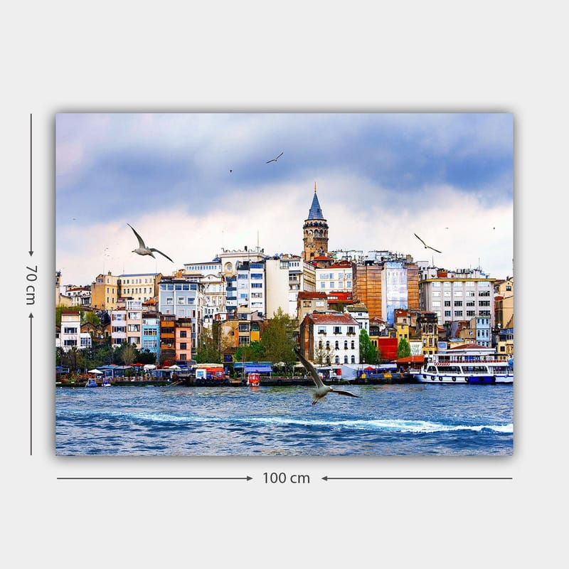 Canvas taulu 70x100 cm - Näkymä kaupunkiin historiallisen kellotornin ja veden yllä liitelevien lintujen kanssa - Sininen / Valkoinen / Beige - Sisustustuotteet - Taulu & taide - Canvas-taulu