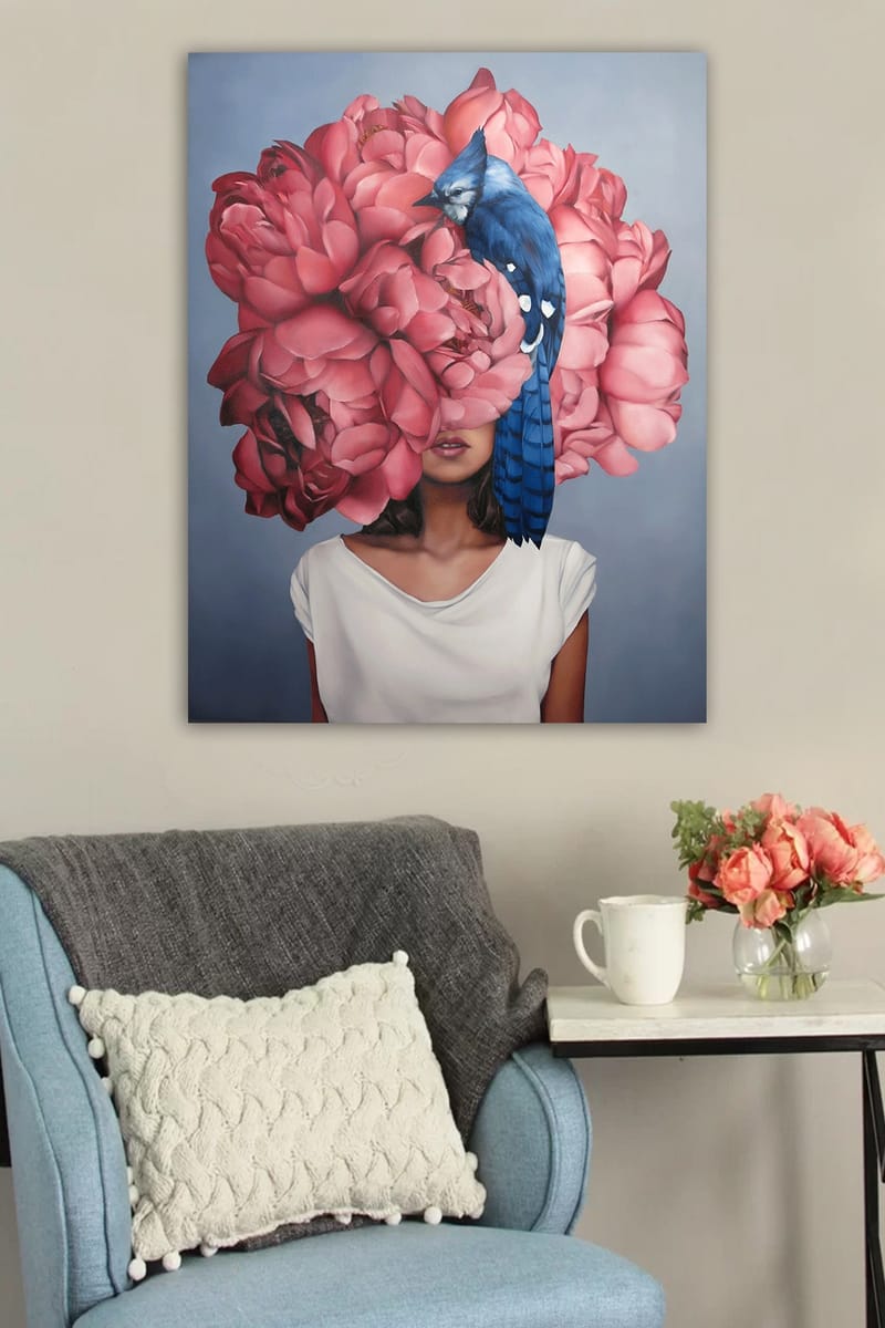 Canvas taulu 70x100 cm - Nainen, jonka päässä on suuri vaaleanpunaisista kukista tehty seppele, ja sininen lintu istuu kukkien päällä - Vaaleanpunainen / Sininen - Sisustustuotteet - Taulu & taide - Canvas-taulu