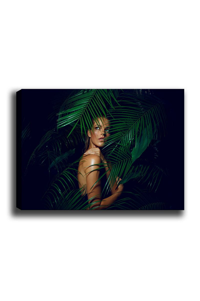 Canvas taulu 70x100 cm - Nainen osittain piilossa vihreiden palmunlehtien takana, Tummanvihreä / Vaaleanvihreä / Beige